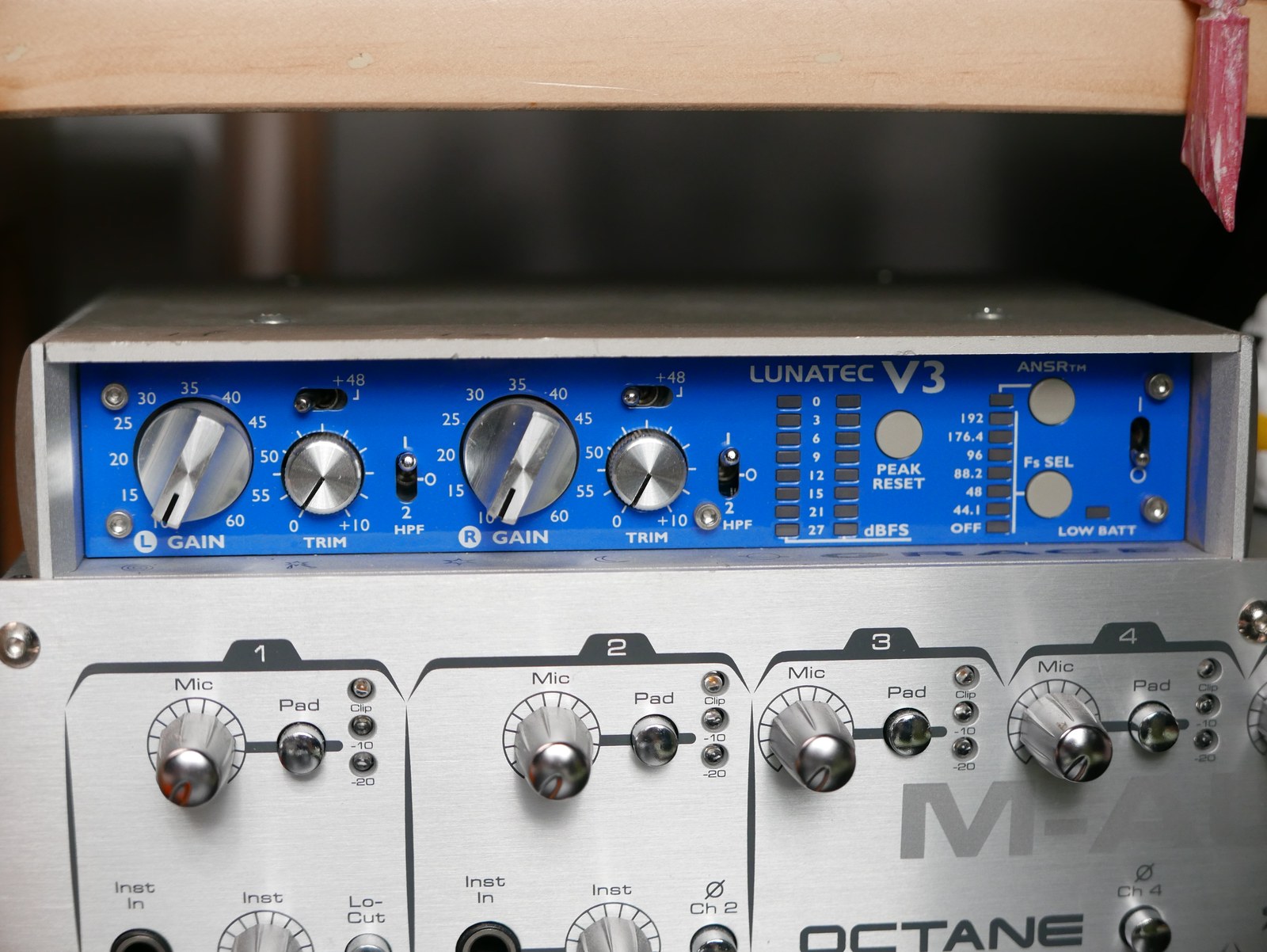 機櫃上下疊著兩台錄音前級，上層是藍色面板的 Grace Design Lunatec V3，下層是 M-Audio Octane